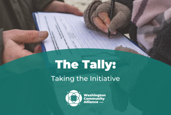 Graphic for The Tally blog titled "Taking the Initiative" with a photo of a gloved hand signing a signature collection sheet.